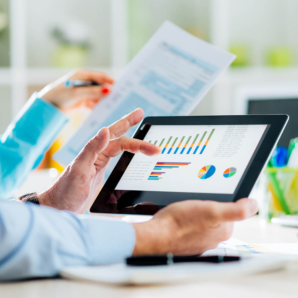 Person holding a tablet displaying charts and graphs